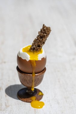 Beyaz ahşap masa arka plan üzerinde tost tost dilim ile eggcup yumuşak haşlanmış yumurta