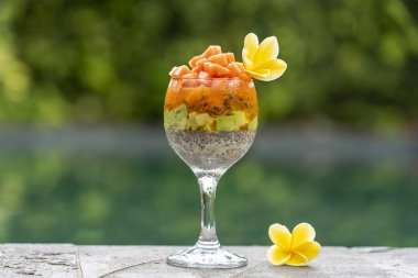 Papaya ile Chia tohumları puding , tutku meyve, mango ve avokado yüzme havuzu su arka planda kahvaltı için bir bardak, closeup. Sağlıklı beslenme kavramı, superfood