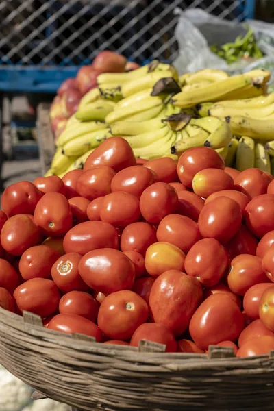 Tomates rojos frescos junto con plátanos para la venta en el mercado local, India. De cerca. — Foto de Stock