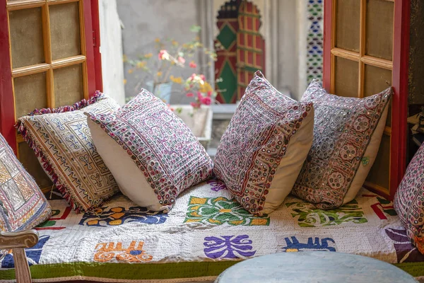 Uma área de estar acolhedora perto da janela com travesseiros coloridos com uma vista maravilhosa do pátio em Udaipur, Rajasthan, Índia . — Fotografia de Stock