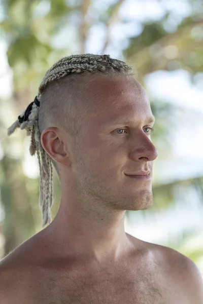 Retrato de un joven con rastas en la cabeza en la naturaleza. De cerca. — Foto de Stock