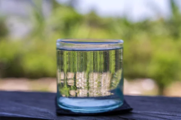 Verre avec de l'eau fraîche sur une table en bois à l'extérieur, gros plan — Photo