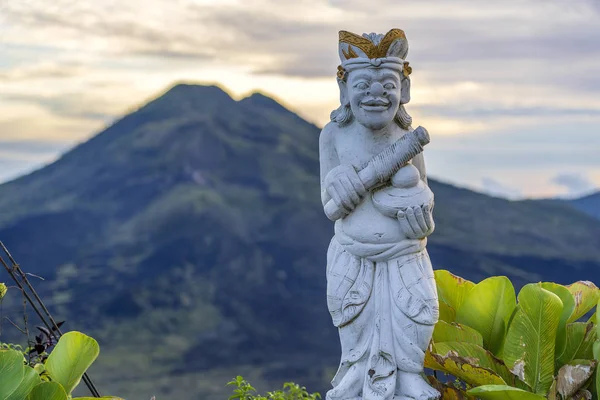 Traditionell balinesisk skulptur mot bakgrunden av vulkanen Batur på soluppgången, morgon tid. Ön Bali, Indonesien. Närbild — Stockfoto