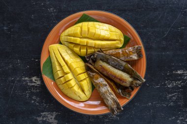 Tay tarzı tatlı, palmiye yaprakları muz yapışkan pirinç sarı Mango. Sarı mango ve yapışkan pirinç Tayland popüler geleneksel gıda. Closeup