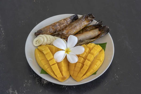 Dolce tailandese, mango giallo con riso appiccicoso alla banana in foglie di palma. Mango giallo e riso appiccicoso è popolare cibo tradizionale della Thailandia. Primo piano — Foto Stock