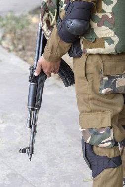 Otomatik makine silah doğrultmak savaşçı. Yeni Delhi, Hindistan.