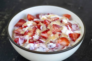 Kırmızı çilek ve beyaz yoğurt brulee. Mevsimlik çilek, mükemmel olgunlaşmış takozlar ile kahvaltıda meyve tatlısı