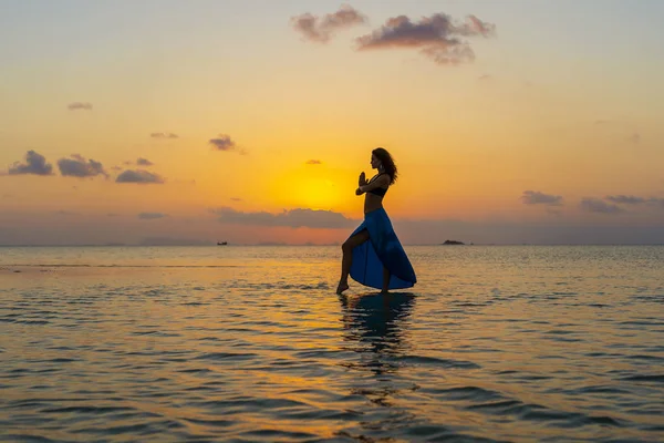 Junges Schönheitsmädchen, das am tropischen Strand auf dem Meerwasser der Paradiesinsel bei Sonnenuntergang tanzt. Sommerkonzept. Urlaubsreise. — Stockfoto