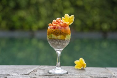 Papaya ile Chia tohumları puding , tutku meyve, mango ve avokado yüzme havuzu su arka planda kahvaltı için bir bardak, closeup. Sağlıklı beslenme kavramı, superfood
