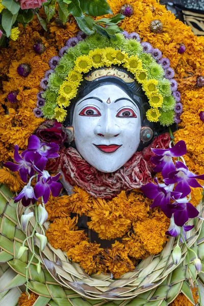 Traditionele Balinese stenen beeldje van de godheid versierd met bloemen in de straat tempel. Eiland Bali, Indonesië. Close-up — Stockfoto