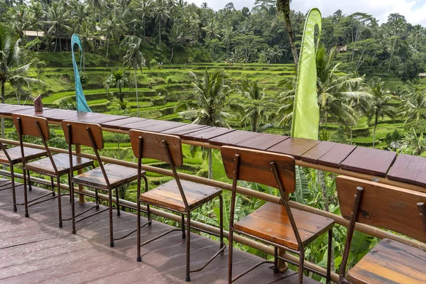 Mesa y sillas de madera en un café tropical vacío junto a terrazas de arroz en la isla de Bali, Indonesia — Foto de Stock