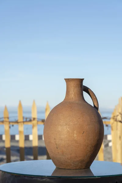 Grande brocca di terracotta si trova su un tavolo sulla riva vicino all'acqua di mare a Batumi, Georgia . — Foto Stock