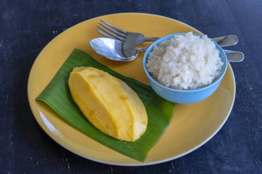 Tay tarzında tatlı, plaka üzerinde yapışkan pirinç ile mango. Sarı mango ve yapışkan pirinç olduğunu Tayland popüler geleneksel tatlı
