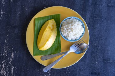 Tay tarzında tatlı, plaka üzerinde yapışkan pirinç ile mango. Sarı mango ve yapışkan pirinç olduğunu Tayland popüler geleneksel tatlı