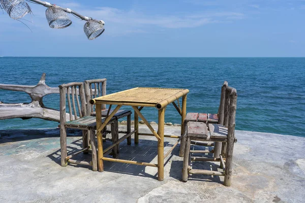 Bamboe tafel en houten stoelen in leeg café naast zeewater in tropisch strand. Eiland Koh Phangan, Thailand — Stockfoto