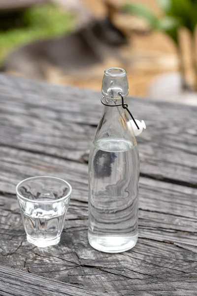 Botella y vaso con agua en la mesa de madera — Foto de Stock