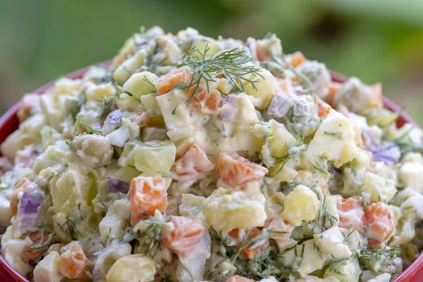 Gezonde zelfgemaakte Russische traditionele salade Olivier klaar om te eten, close-up — Stockfoto