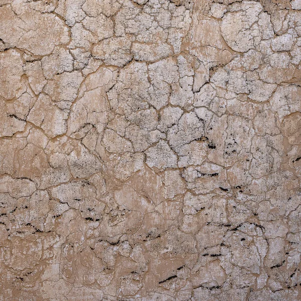 Cracked concrete old wall covered with beige cement surface as background. Textured background old cracked wall