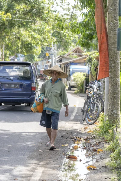 Un Indonésien en chapeau de paille est en route vers un marché local dans la ville d'Ubud, île de Bali, Indonésie — Photo