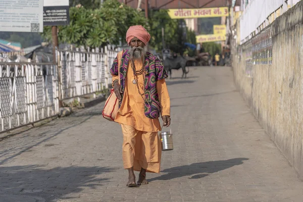 Hinduski sadhu święty człowiek idzie w dół ulicy obok Ghat w pobliżu rzeki Ganges w Rishikesh, Indie, zbliżenie — Zdjęcie stockowe