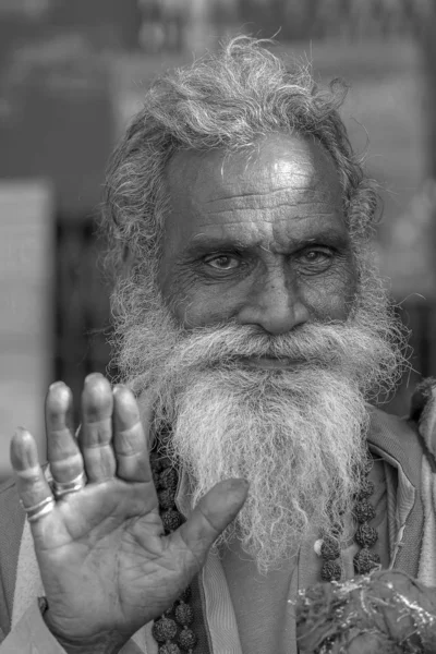 Porträt des heiligen Hindu Sadhu, sitzt auf dem Ghatt und bittet Passanten in der Nähe des Ganges River in Rishikesch, Indien, um Almosen aus nächster Nähe. schwarz-weiß — Stockfoto