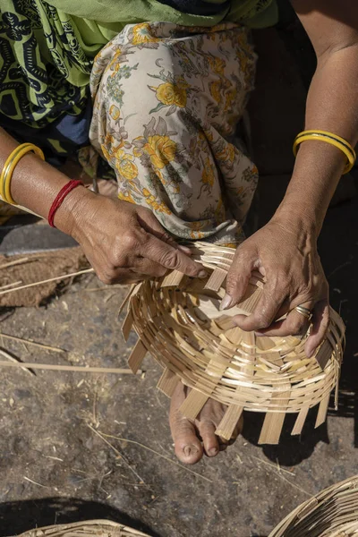 Eine indische Frau webt auf einem Markt einen Bambuskorb mit Beinen und Armen, in Großaufnahme. Indien — Stockfoto