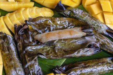 Tay tarzı tatlı, palmiye yapraklarımuz yapışkan pirinç ile sarı mango. Sarı mango ve yapışkan pirinç Tayland popüler geleneksel tatlı.