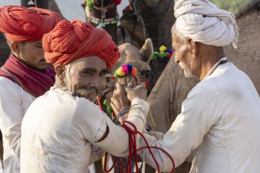 Pushkar Camel Mela, Rajasthan, Hindistan sırasında Hintli adam ve solana