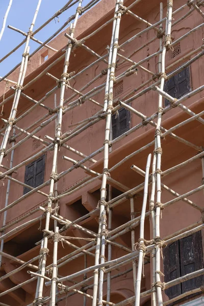 Bambusgerüst am Haus, Renovierung. Baugerüste, rosa Wand und Fenster. jaipur, indien — Stockfoto