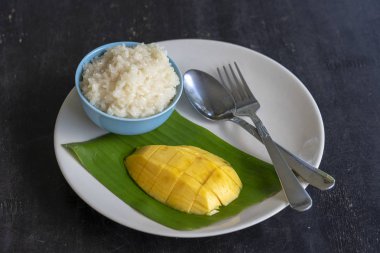 Tay tarzında tatlı, plaka üzerinde yapışkan pirinç ile mango. Sarı mango ve yapışkan pirinç olduğunu Tayland popüler geleneksel tatlı