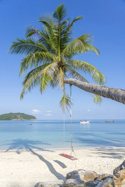 Columpio cuelgan de la palmera de coco sobre la playa de arena cerca del agua azul del mar en Tailandia. Verano, viajes, vacaciones y concepto de vacaciones —  Fotos de Stock