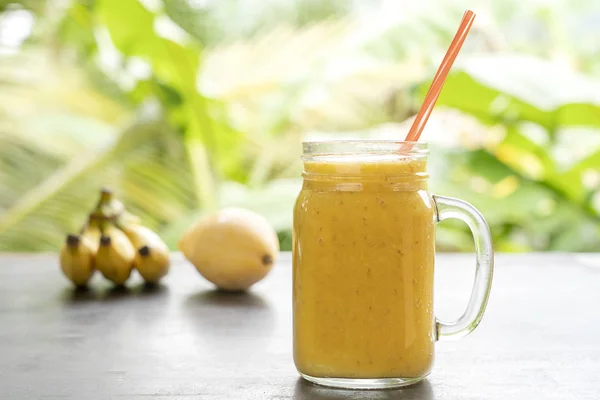 Smoothie med tropiska frukter: mango, banan, ananas i en glasburk på träbordet. Begreppet hälsosam livsstil. Närbild — Stockfoto