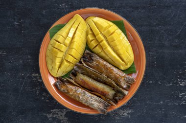 Tay tarzı tatlı, palmiye yaprakları muz yapışkan pirinç sarı Mango. Sarı mango ve yapışkan pirinç Tayland popüler geleneksel gıda. Closeup