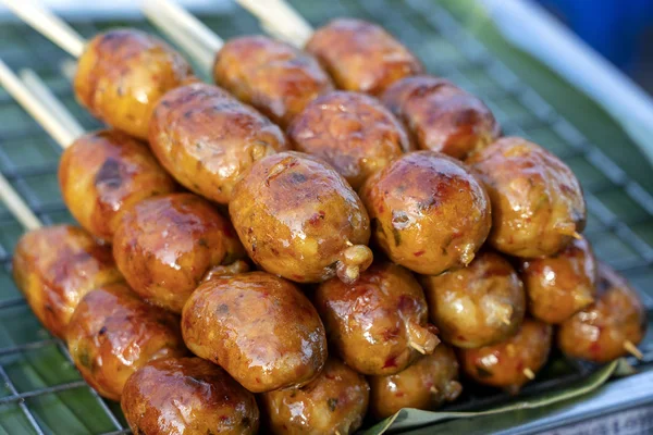 Salsicha tailandesa grelhada no mercado de comida de rua na Tailândia, close up. Salsicha tailandesa tradicional com carne de porco e arroz, deliciosa comida de rua — Fotografia de Stock