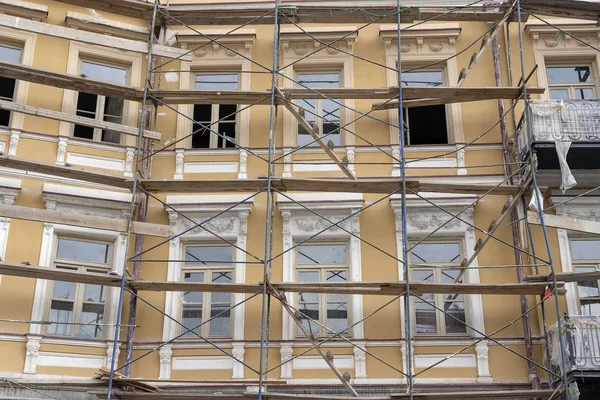 Andamio en casa, renovación. Andamios en edificio, pared y ventana beige — Foto de Stock