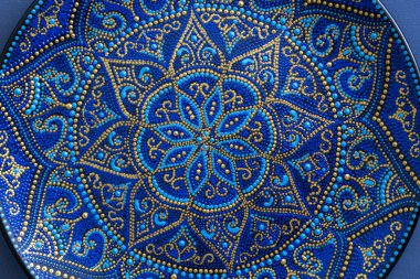 Mavi ve altın rengi nde dekoratif seramik tabak, boyalı tabaklar, closeup. Akrilik boyalar ile boyanmış dekoratif porselen plaka, el işi