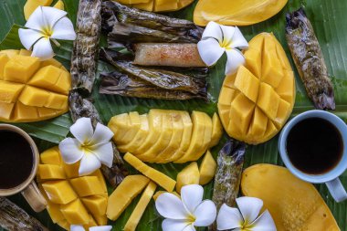 Tay tarzı tatlı, palmiye yapraklarımuz yapışkan pirinç ile sarı mango. Sarı mango ve yapışkan pirinç Tayland popüler geleneksel tatlı.