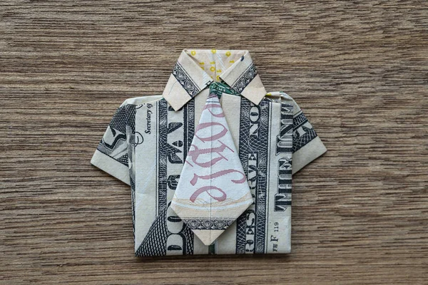 Camisa Origami feita de nota de dólar sobre fundo de madeira. Fecha a porta. T-shirt de nota de dólar — Fotografia de Stock