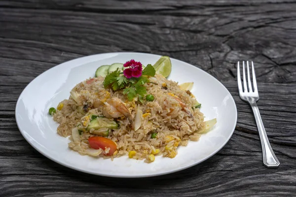 Gebakken rijst met garnalen en groenten in een witte schaal op een oude houten tafel, close-up. Thais eten, Thaise keuken — Stockfoto