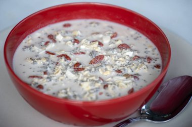 Granola, yoğurt, fındık, Goji çilek, Chia tohumları ve muz taze kahvaltı. Kırmızı kase meyve ve çilek ile muesli