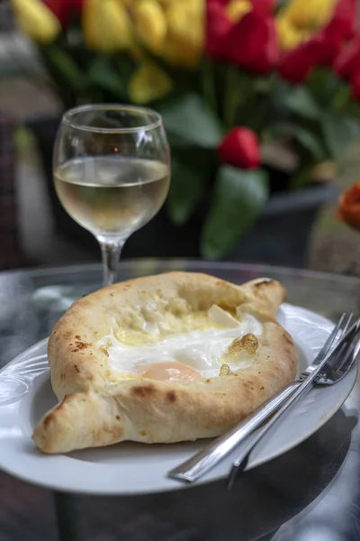 Adjarian Khachapuri no restaurante. Torta de pão aberta com queijo e gema de ovo. Gastronomia georgiana gostosa. — Fotografia de Stock