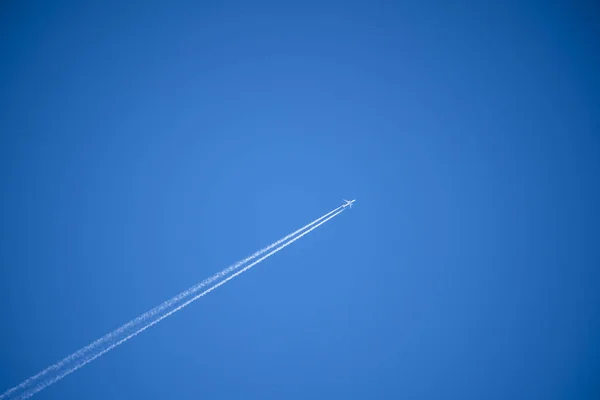 Airplane in the sky. An airplane trail across the sky — Stock Photo, Image