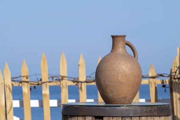 Grande cruche en terre cuite se tient sur une table sur le rivage près de l'eau de mer à Batoumi, Géorgie . — Photo