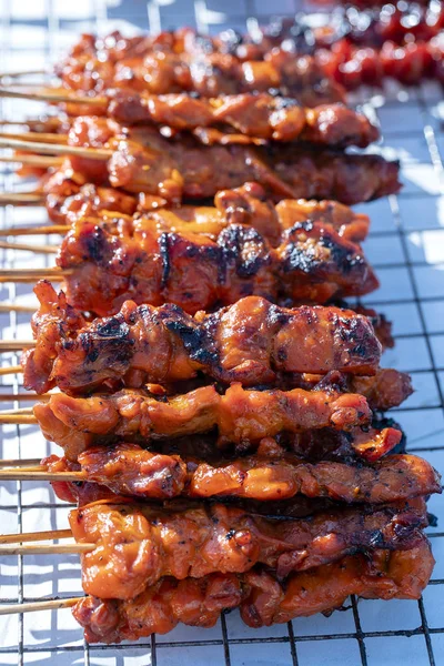 O vendedor de rua tailandês vende carne de frango grelhada no mercado de comida de rua na ilha Koh Phangan, Tailândia. Fechar. — Fotografia de Stock