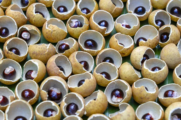La cáscara y el hueso de la fruta tailandesa longan. Cáscara de piel de Longan y fondo de grano. Fruta exótica en Tailandia, primer plano — Foto de Stock
