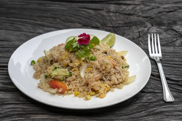Smażony ryż z krewetek i warzyw w białym naczyniu na starym drewnianym stole, z bliska. Kuchnia tajska, kuchnia tajska — Zdjęcie stockowe