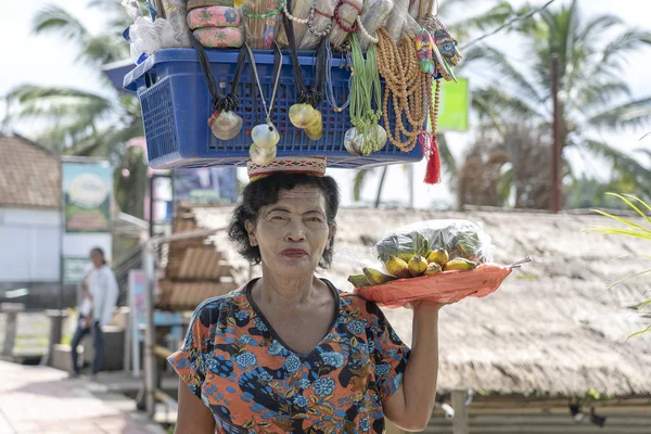 Mujer indonesia vendiendo frutas tropicales y recuerdos para turistas en un mercado callejero en Ubud, isla Bali, Indonesia — Foto de Stock