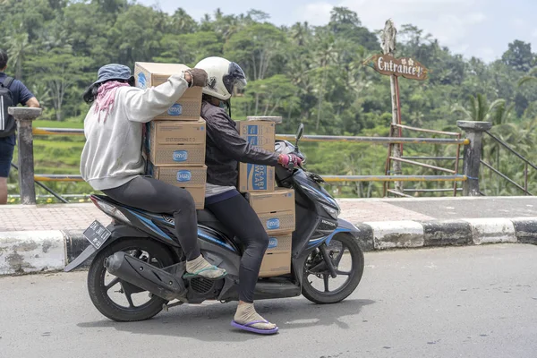 Deux femmes transportent des marchandises sur une moto dans une rue à Ubud, île de Bali, Indonésie, gros plan — Photo