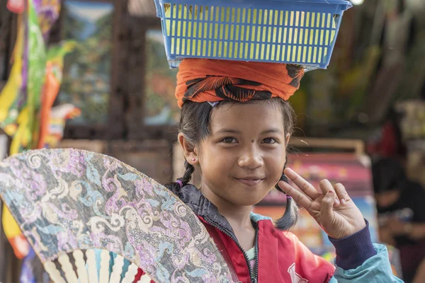 年轻的印度尼西亚女孩在巴厘岛乌布市的一个街市为游客卖粉丝 — 图库照片