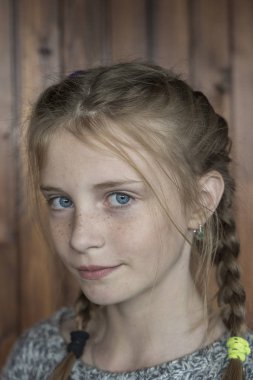 Ahşap arka plan, closeup portre üzerinde kapalı çiller ile güzel sarışın genç kız